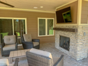 outdoor TV and fireplace with chairs
